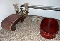 Photo of antique wooden stool, vintage double hurricane lamp, Asian ceramic box, and red wooden basket all placed on carpet.