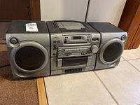 Front view of Aiwa boom box showing speakers, cassette player, and control buttons.