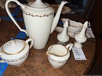Photo showing full coffee set including coffee pot, lidded sugar bowl, creamer, and salt and pepper shakers on table