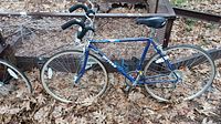 Side view of the blue Miyata One Twelve road bike showing frame, wheels, tires, and drivetrain components.