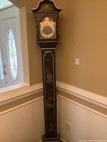 Full tall grandmother clock with visible clock face and hand-painted Asian style panels along the upright body.