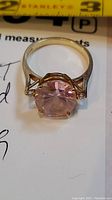 Close-up of 10K gold ring showing front view of the pink round stone and gold prong setting.