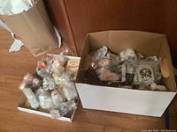 Box containing multiple collectible salt and pepper shakers wrapped in bubble wrap.