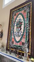 Full view of the framed stained glass panel showing overall design and wooden frame.