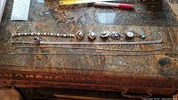 All silver jewelry items displayed on a marble surface including necklaces, earrings, and a pin.