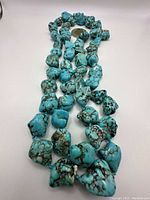 Full view of turquoise nugget necklace laid out showing the variety of stone shapes and veining pattern.