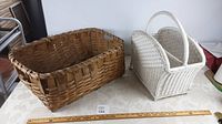 Overview of both baskets on a white surface with a measuring ruler, showing relative sizes and condition