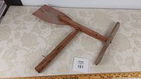 Antique wooden weathervane whirlygig top view on fabric surface with ruler for scale.