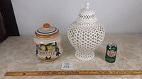 Overall shot of both items side by side with soda can for scale, showing biscotti jar and pierced jardiniere on a table.
