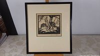 Framed woodblock print centered on table, showing full frame and mat.