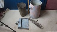 Overall display of all four metal vintage items: sap bucket, dust pan, metal rack head, and tall bucket