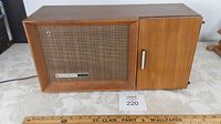 Front view of the vintage Panasonic radio in teak cabinet showing woven speaker grille and wood cabinet.