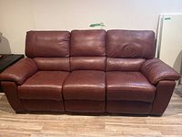 Front view of brown leather three-seater couch