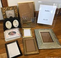 Overview of all 10 picture frames in varying styles and sizes arranged on wooden floor