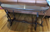 Dark wood sofa table with scalloped edge top and scroll legs photographed from front and side angles.