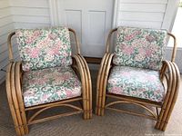 Pair of vintage bamboo armchairs with rounded bamboo frames and floral cushions, showing overall design and size