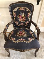 Front view of vintage needlepoint upholstered side chair showing detailed floral needlepoint on seat and backrest with carved wood frame and nail head trim.