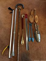 All items laid out on carpet showing walking canes, shoehorns, shoe trees, and grabber