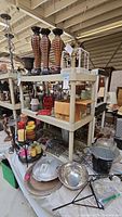 Wide shot of the shelf with wooden candleholders, candles, metal baskets, and other items
