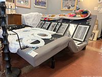 Pair of adjustable bed bases displayed side by side with fabric upholstery and decorative items on top