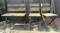 Set of three outdoor chairs showing wood seats and backrests with metal legs and frames, weathered condition.