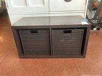 Front view of rectangular laminate composite storage unit with two dark brown woven plastic drawers with cut-out handles.