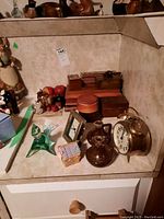 Overview of lot showing wood boxes, ceramic pitchers, metal alarm clock, glass bird figurine, and decorative birdhouse