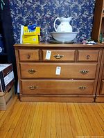 Front view of Vilas wood dresser with three drawers, showing medium wood finish and mix of metal and wooden drawer handles.