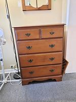 Front view of the Vilas wooden dresser showing four drawers and metal handles.