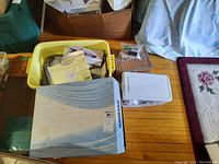Large yellow plastic bin with quilting materials, templates, and other sewing supplies spread inside and nearby