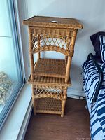 Full view showing the two stacked wicker bedside tables with shelves and diamond lattice sides.
