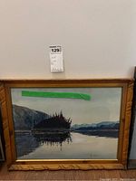 Framed watercolour landscape painting showing the full image with reflection and wooden frame with carved edges, alongside a green tape note indicating art and frame dimensions.