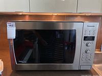 Front view of Panasonic NN-SD797S microwave convection oven showing stainless steel body and large viewing window with control panel on side.