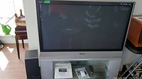 Front view of Panasonic 42-inch TV with Energy speakers and media components on glass shelf below