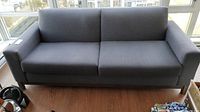 Front view of the grey fabric sofa showing two removable cushions and armrests.