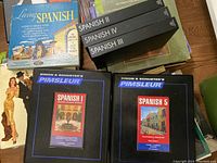 Photo of several Spanish language learning boxed sets including Living Spanish records and Simon & Schuster Pimsleur Spanish boxed CD sets for Spanish I and Spanish V.