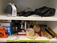 Shelving with various tools, tapes, batteries, and a black pouch
