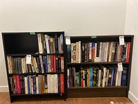 Front view of two bookshelves filled with books, showing condition and size for reference.
