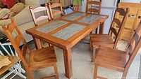 Six solid wood dining chairs around a dining table showing the overall set and finish.