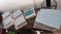 Overall overview of the boxed decorative kits alongside the multi-pocket album pages on a table.