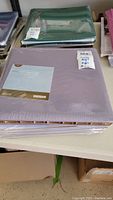 Photo of unopened lavender Creative Memories scrapbook album on table, still sealed with original packaging and labels visible.