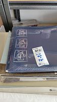 Blue Creative Memories 12x12 scrapbook album sealed in plastic with white Christmas gift box illustrations on cover