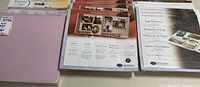 Set of scrapbook pages and page protectors in packaging showing assorted layouts and labels.