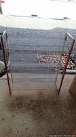 Full view of the 4-shelf shoe rack showing wooden sides and metal mesh shelves.