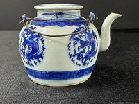 Side view showing porcelain blue dragon design and metal wire handle