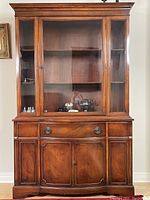 Full view of the two-piece mahogany Bernhardt china cabinet showing glass doors on the top portion and wood on the bottom.