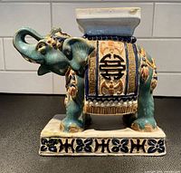 Front view of ceramic Asian elephant figurine showing decorations and Double Happiness symbol.