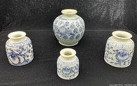 Four Chinese porcelain ink pots arranged on black background showcasing varied blue floral patterns and shapes.