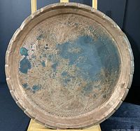 Front view of copper serving tray showing detailed etched designs and tarnished surface with verdigris spots