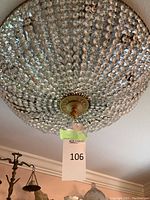 Dome-shaped chandelier with clear faceted glass beads over gold-tone metal frame, tagged with lot number 106